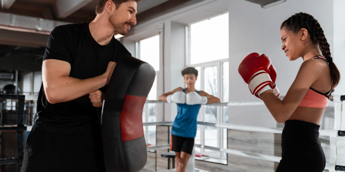boxing supplies shop 10 boxing supplies shop -boxing supplies shop side view coach helping girl boxing 1200x600 1